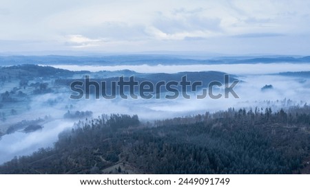 Stunning drone aerial landscape image of cloud inversion around Esthwaite Water in Lake District during Spring sunrise blue hour Royalty-Free Stock Photo #2449091749