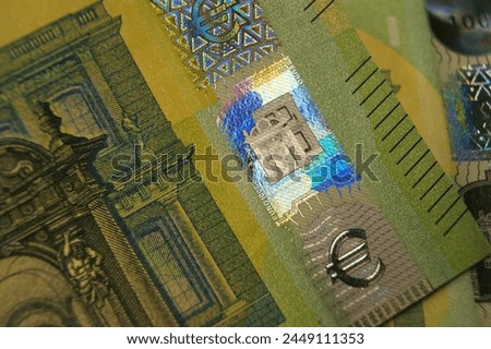  A fragment of a 100 euro banknotes with a hologram. Euro symbol.