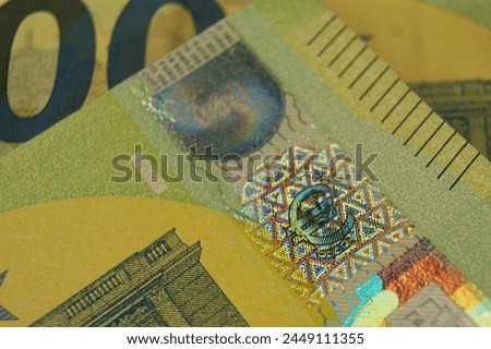 A fragment of a 100 euro banknotes with a hologram. Euro symbol.