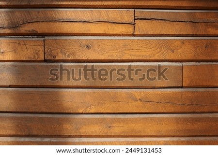 An old orange wooden wall created out of felled trees and logs.
