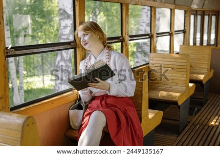Young woman reads book on tram. USSR style. Free space for text