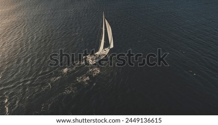Yacht sailing on open sea at sun shine aerial. Serene seascape and water transportation. Lonely sail boat cruising at wind sunny day. Nobody nature landscape at cinematic drone shot