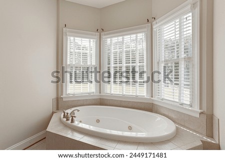 Sunlit Bathroom with An Elegant Bathtub with A Large Bay Window Offering Natural Light Royalty-Free Stock Photo #2449171481