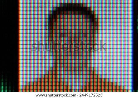 A highly magnified view of a screen displaying a pixelated image of a person.