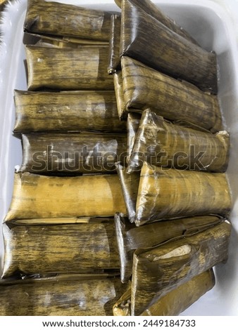 The name of this food is buras. made from rice, coconut milk and salt, cooked then wrapped in banana leaves then boiled for 6 hours until solid. it tastes very delicious and savory. Royalty-Free Stock Photo #2449184733