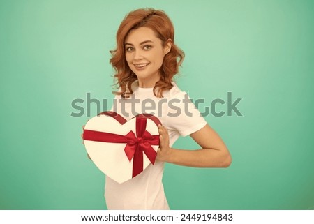 happy girl hold heart gift box on blue background