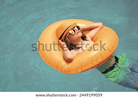 Happy child enjoying summer vacation outdoors in the water in the swimming pool.