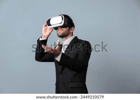 Smart business man holding something while touching VR goggle. Project manager planning marketing strategy while using visual reality headset to connect metaverse. Technology innovation. Deviation.