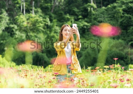 Lifestyle traveler women raise hand feeling good relax and cosmos farm in the sunrise morning. Travel and summer Concept
