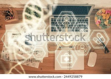DNA hologram drawings over computer on the desktop background. Top view. Multi exposure. Concept medical education.