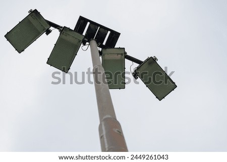 Softball field lamps with a grey sky background