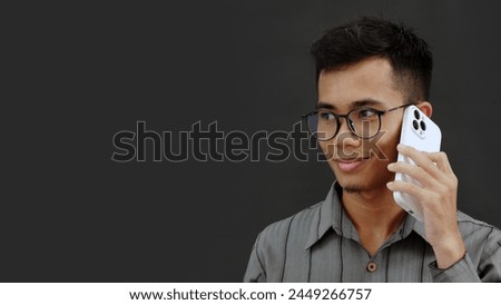 Asian man calling using smartphone isolated on gray background. Communication, Phone Call.