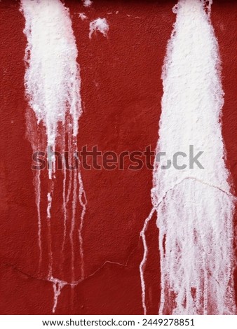 a photography of a red wall with white paint and a fire hydrant.