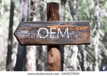 OEM original equipment manufacturer concept. Text on a wooden signpost against a forest background