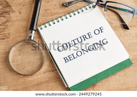 Culture of belonging symbol on a notebook with a magnifying glass and glasses on a vintage background