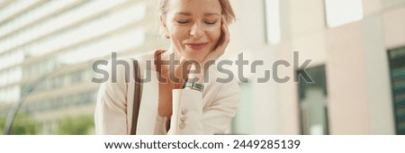 Businesswoman with blond hair typing on cellphone, Close-up, Panorama