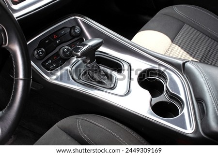 Supercharged muscle car Automatic gearbox lever. Automatic gear stick inside modern car. Detail on a automatic gear shifter in a car. Royalty-Free Stock Photo #2449309169
