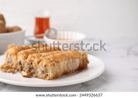 Eastern sweets. Pieces of tasty baklava on white marble table, closeup. Space for text