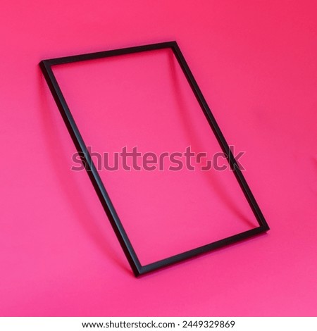Blank black photo frame on pink background creative background concept. Copy space for text.