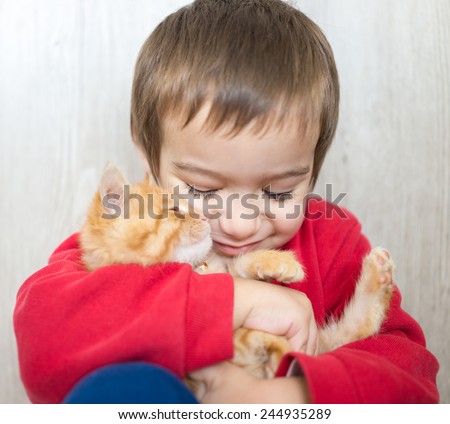 Portrait of child holding yellow kitty cat