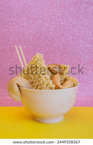 A bowl with dried noodles, fortune cookies and chopsticks Royalty-Free Stock Photo #2449358367