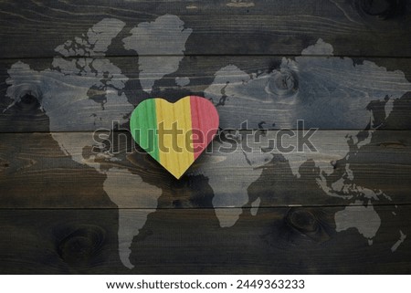 wooden heart with national flag of mali near world map on the wooden background. concept