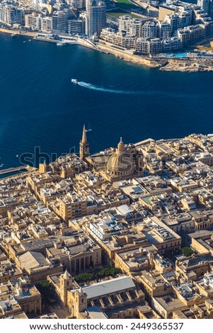 The capital city of Malta, Valletta, as seen from the sky with St. Paul's Cathedral dominating the skyline and the Mediterranean Sea surrounding the coast.