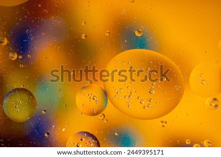 Macro photography of yellow oil bubbles dissolved in water. Colorful background.