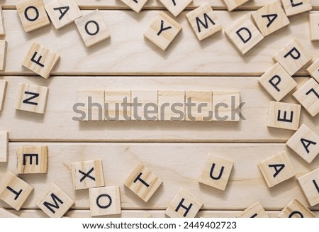 A wooden board with a crossword puzzle on it. The puzzle is made up of wooden blocks and the letters are scattered around the board