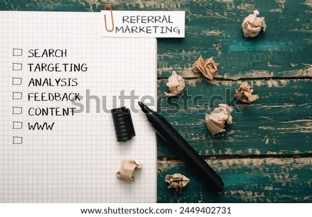 A piece of paper with a marker on it with the words referral marketing written in red