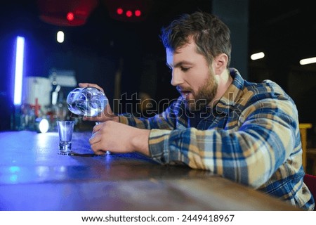 It was a hard day. Depressed young man drinking vodka in bar. Royalty-Free Stock Photo #2449418967