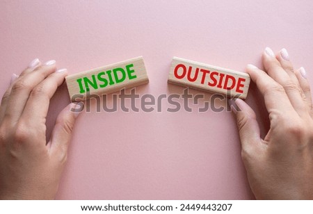 Inside or Outside symbol. Concept word Inside or Outside on wooden blocks. Businessman hand. Beautiful pink background. Business and Inside or Outside concept. Copy space