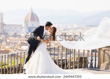 Beautiful bride and groom hugging and kissing on their wedding day. Bride and groom on natural fairy background. 