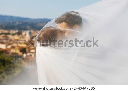 Beautiful bride and groom hugging and kissing on their wedding day. Bride and groom on natural fairy background. 
