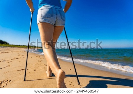 Nordic walking - beautiful woman exercising on beach 