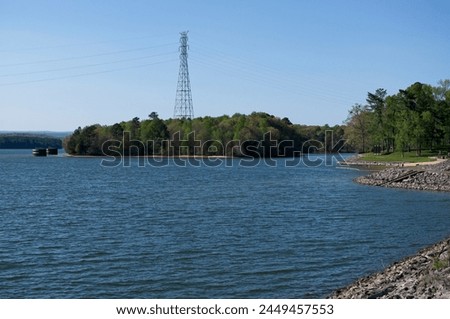 Electric tower with a lake in the foreground Royalty-Free Stock Photo #2449457553