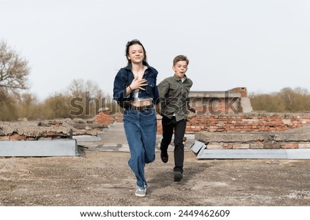 Sister and younger brother walking in the park near the old fortress