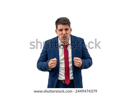 intense fury of a businessman as he glares furiously at the camera, with clenched fists, displaying a expression of maximum anger and contained rage,  indignation and frustration white background Royalty-Free Stock Photo #2449474379