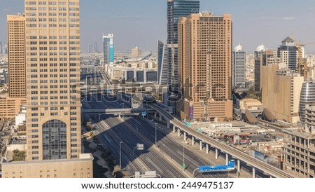 Skyline internet city with crossing Sheikh Zayed Road aerial timelapse before sunset. Skyscrapers with traffic on a highway and metro line in Dubai
