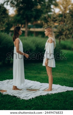 Standing on boards with nails. Young women practicing yoga and therapy in nature. High quality photo