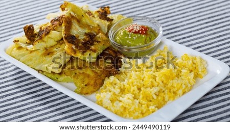Vegetarian dish of leaves of cabbage in batter with rice and green pea sauce