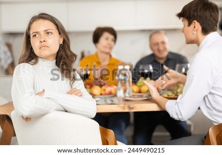 Upset young woman at family holiday table with parents at home. Unpleasant discussion Royalty-Free Stock Photo #2449490215