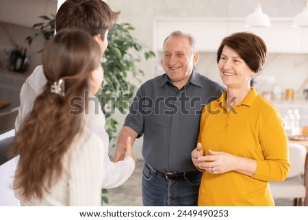 Hospitable parents welcome their adult son and daughter-in-law at home Royalty-Free Stock Photo #2449490253