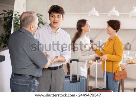 Hospitable parents joyfully welcome their adult children who have come to visit from far away Royalty-Free Stock Photo #2449490347
