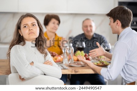 Upset young woman at family holiday table with parents at home. Unpleasant discussion Royalty-Free Stock Photo #2449490547