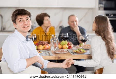 Upset young guy at family holiday table with parents at home. Unpleasant discussion Royalty-Free Stock Photo #2449490641