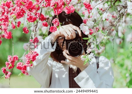 Female photographer taking pictures of bayberry flowers
