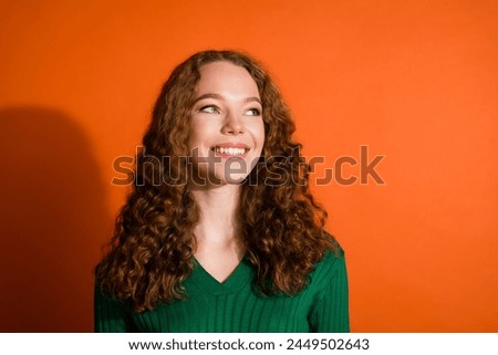 Photo of adorable dreamy lady dressed green shirt looking emtpy space isolated orange color background