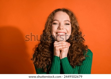 Photo of pretty adorable lady dressed green shirt hands arms chin emtpy space isolated orange color background Royalty-Free Stock Photo #2449502679