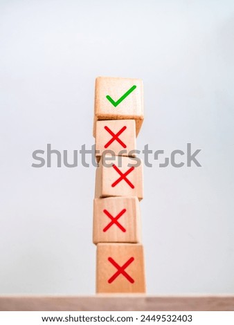 Business solution, strategy and decision, change, development concepts. Green correct check mark icon on wood cube on top, among many red wrong or cross symbol on vertical wooden blocks stack.